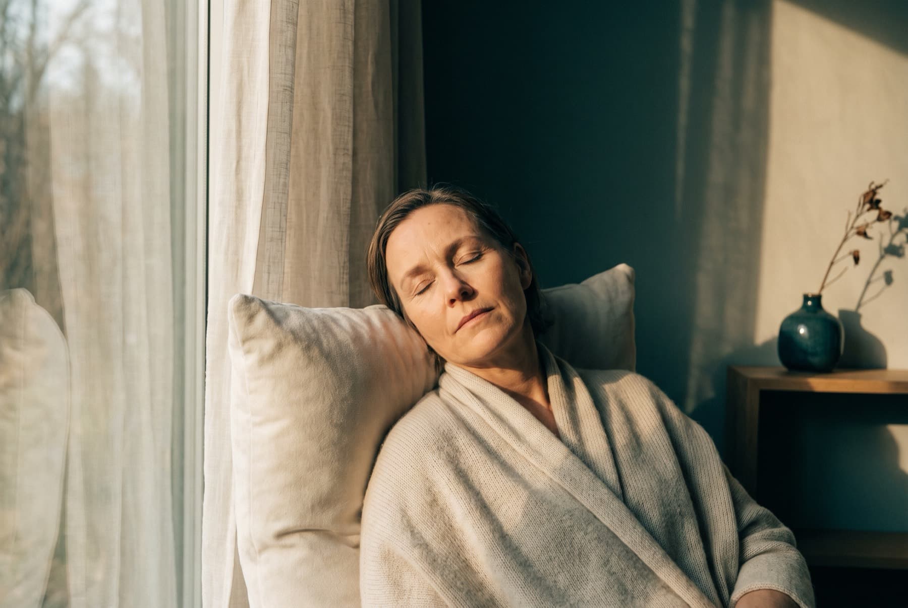 An adult resting comfortably in warm light, eyes gently closed